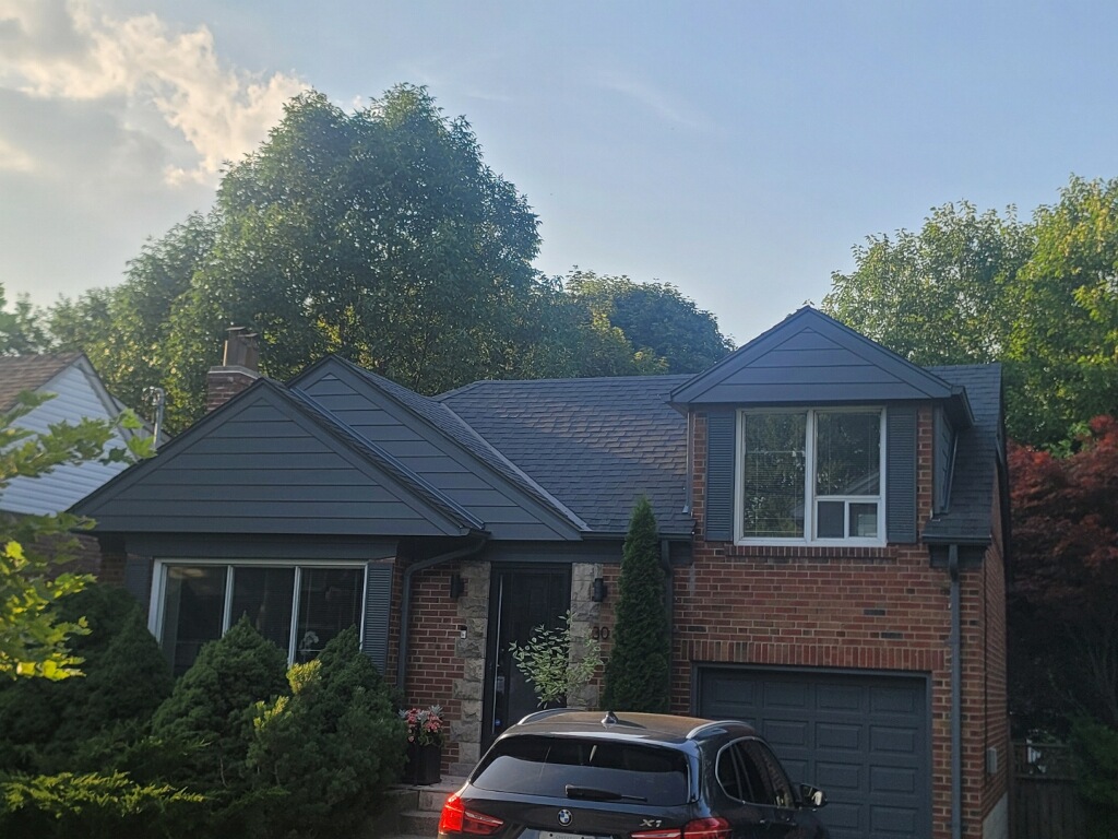 Old vertical wood siding before replacement on a home in The Kingsway, Toronto