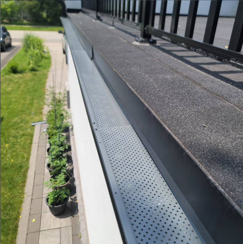 Aftermarket leaf guard installed over an existing eavestrough by Kubura Siding